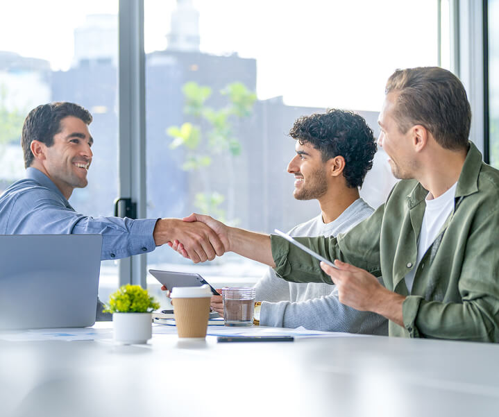 Men in boardroom shaking hands